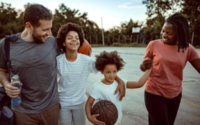 family walking together at a basketball court